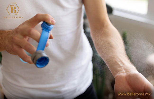 Persona aplicando perfume en su brazo