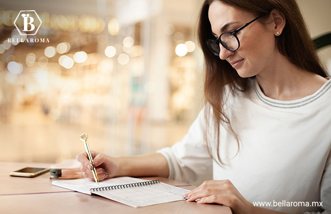 Mujer creando una lista con los perfumes más aceptados por sus clientes