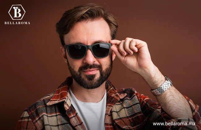 Hombre usando su regalo para papá, unos lentes de sol y tocándolos con su mano izquierda