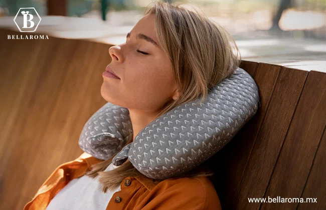Mujer recargada en una banca de madera con una almohada de viaje, una buena opción de productos para revender.