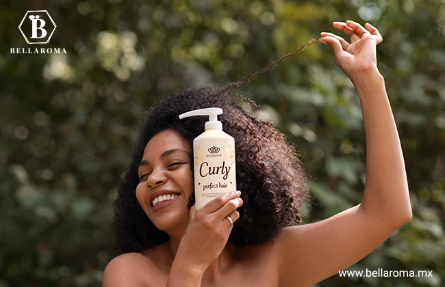 Mujer sonriente mostrando el champoo que utiliza para cuidar y reparar su cabello