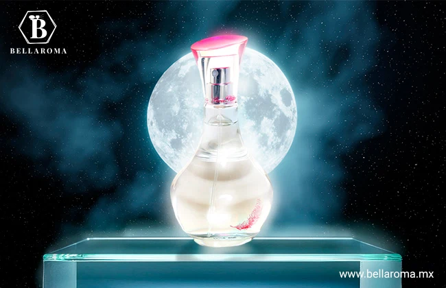 Frasco transparente de Can Can de Paris Hilton con tapa rosa, colocado sobre una base de cristal frente a una luna llena.