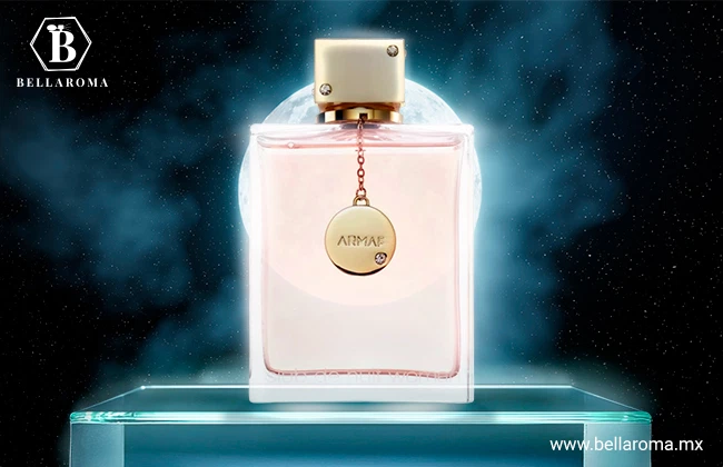 Frasco rosa cuadrado de Club de Nuit de Armaf con dije dorado, presentado con fondo nocturno y luna llena.