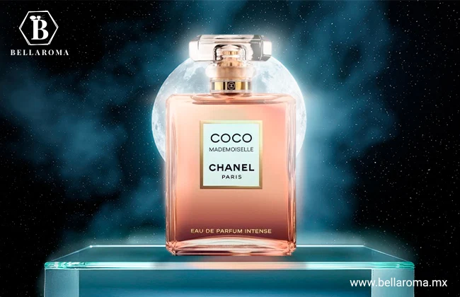 Perfume de noche mujer Coco Mademoiselle de Chanel en frasco rosa transparente, colocado sobre una base de cristal frente a una luna llena.