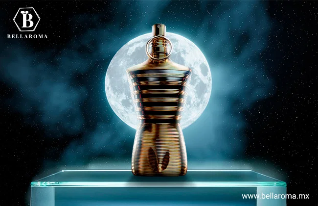 Perfume de noche hombre Le Male Elixir de Jean Paul Gaultier en frasco dorado con forma de torso masculino, sobre una base iluminada con fondo nocturno.