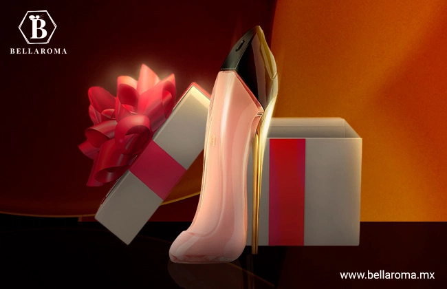 Perfume en forma de zapatilla color rosa de Carolina Herrera, en frente de caja de regalo.