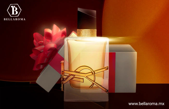 Perfume para regalar de mujer Libre de Yves Saint Laurent en frasco transparente, con tapa negra y detalles dorados, en frente de caja de regalo.