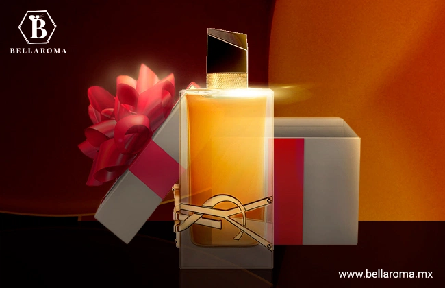 Perfume Libre Intense de YSL en frasco rectangular y detalles dorados, en frente de una caja de regalo con listón rojo.