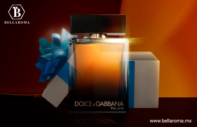 Perfume para regalar de hombre The One for Men de Dolce & Gabbana, frasco negro con naranja y tapa rectangular con una caja de regalo detrás y ambos sobre una base color negro.